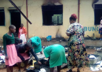 Pupils and teachers sorting out some of their items erased in a school fire.