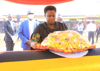 Vice President Jessica Alupo lays a wreath on the casket of Cecilia Ogwal.
