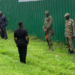 MP Zaake (back camera) interacts with men in UPDF uniform outside the project.