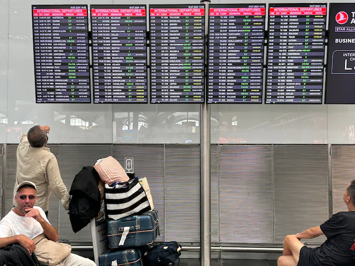 Passengers check flight information at Istanbul Airport in Turkey on Friday. (Tolga Bozoglu/EPA-EFE/Shutterstock) - By Shira Ovide