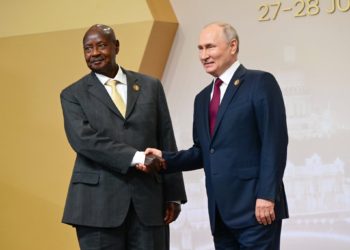 Museveni of Uganda and Vladimir Putin  of Russia shake hands, secretly plotting global oppression and suffering ahead. Image maybe subject to copyright.