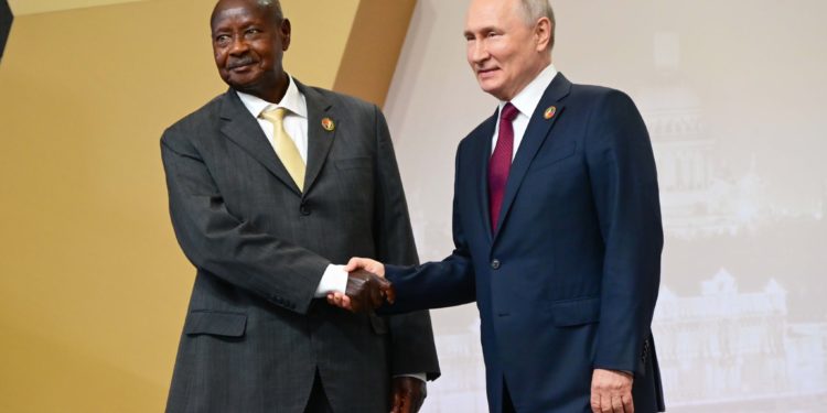 Museveni of Uganda and Vladimir Putin  of Russia shake hands, secretly plotting global oppression and suffering ahead. Image maybe subject to copyright.