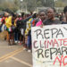 A member of the civil society holds a placard as others queue during a peaceful protest against the continent's inaugural climate summit, marching against the use of fossil fuels in the region while demanding that governments and industries transition to renewable energy in Nairobi, Kenya September 4, 2023. REUTERS/John Muchucha